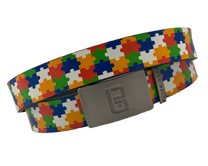 Jigsaw golf belt from Buca Belts, offering a vibrant and unique design. A perfect gift for golfers or those looking to add a stylish touch to their gear. Features a convenient ratchet buckle for easy adjustment.